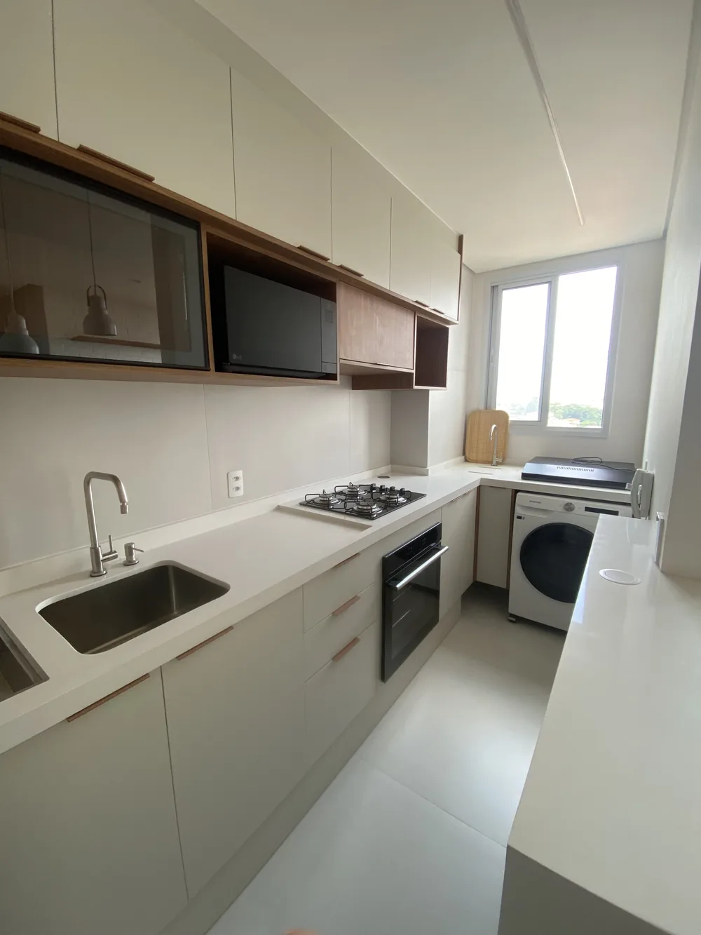Cozinha planejada em corredor com lavanderia integrada, projeto Kidar