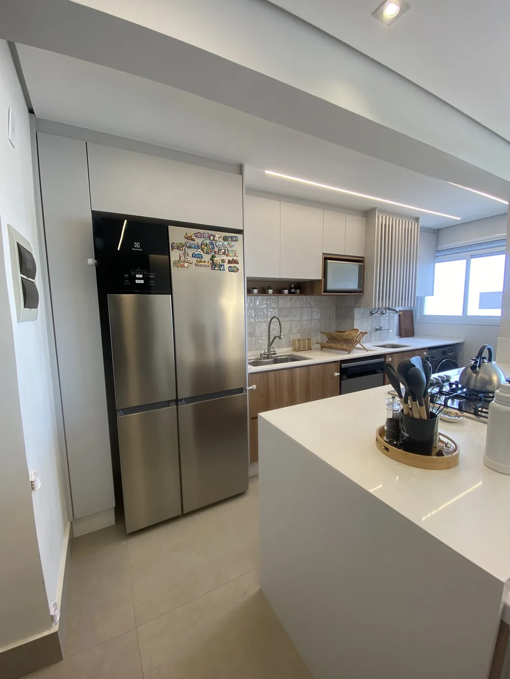 Cozinha planejada branca com ilha e geladeira french door, projeto Kidar